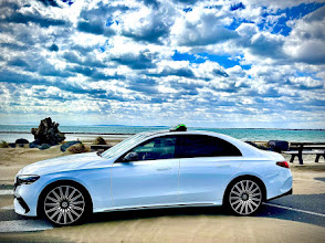 Mercedes berline blanche de Stéphane, équipée d’un lumineux taxi et stationnée en bord de mer.